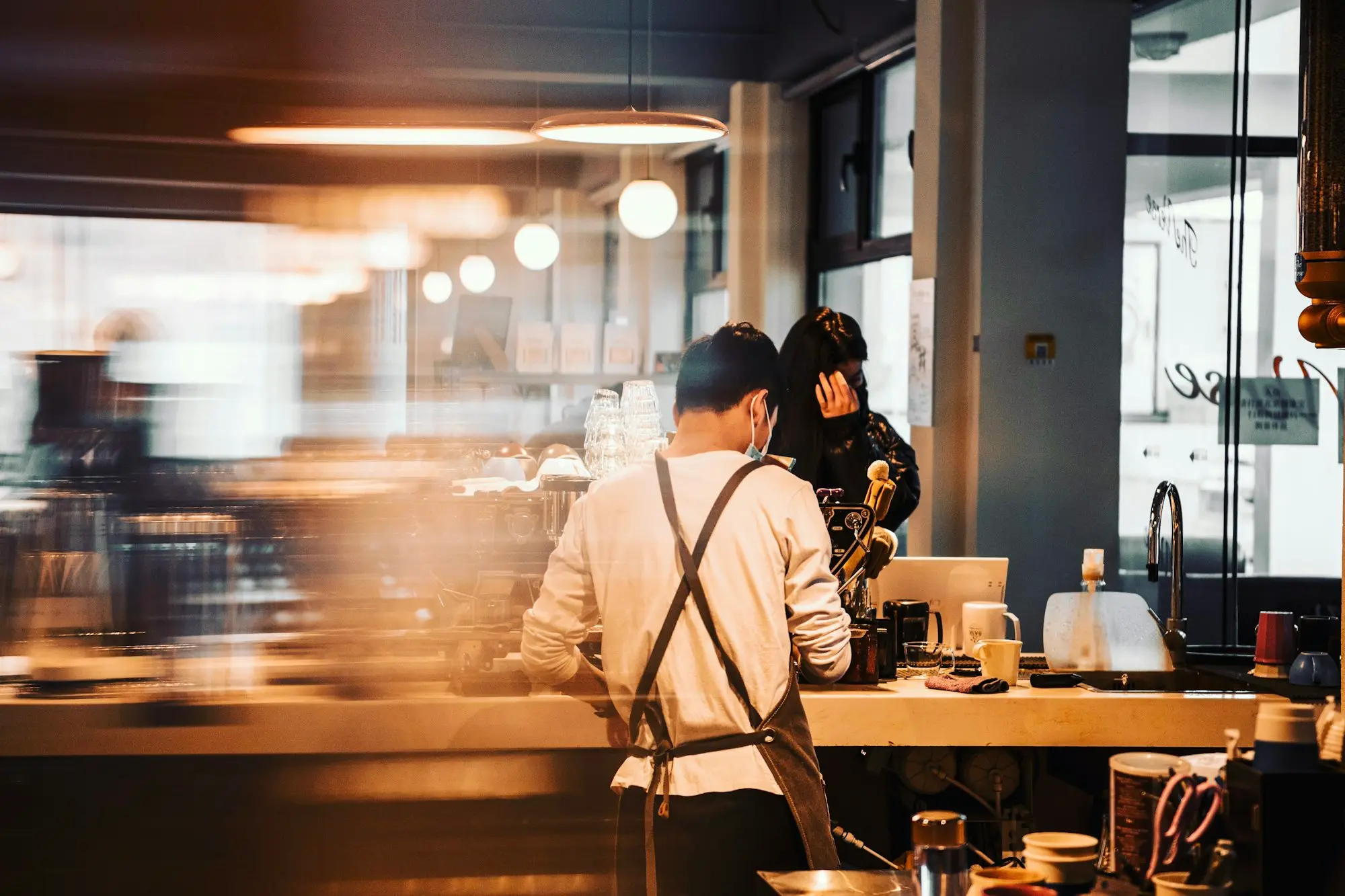 Café owner behind an espresso machine counter in a Melbourne laneway café