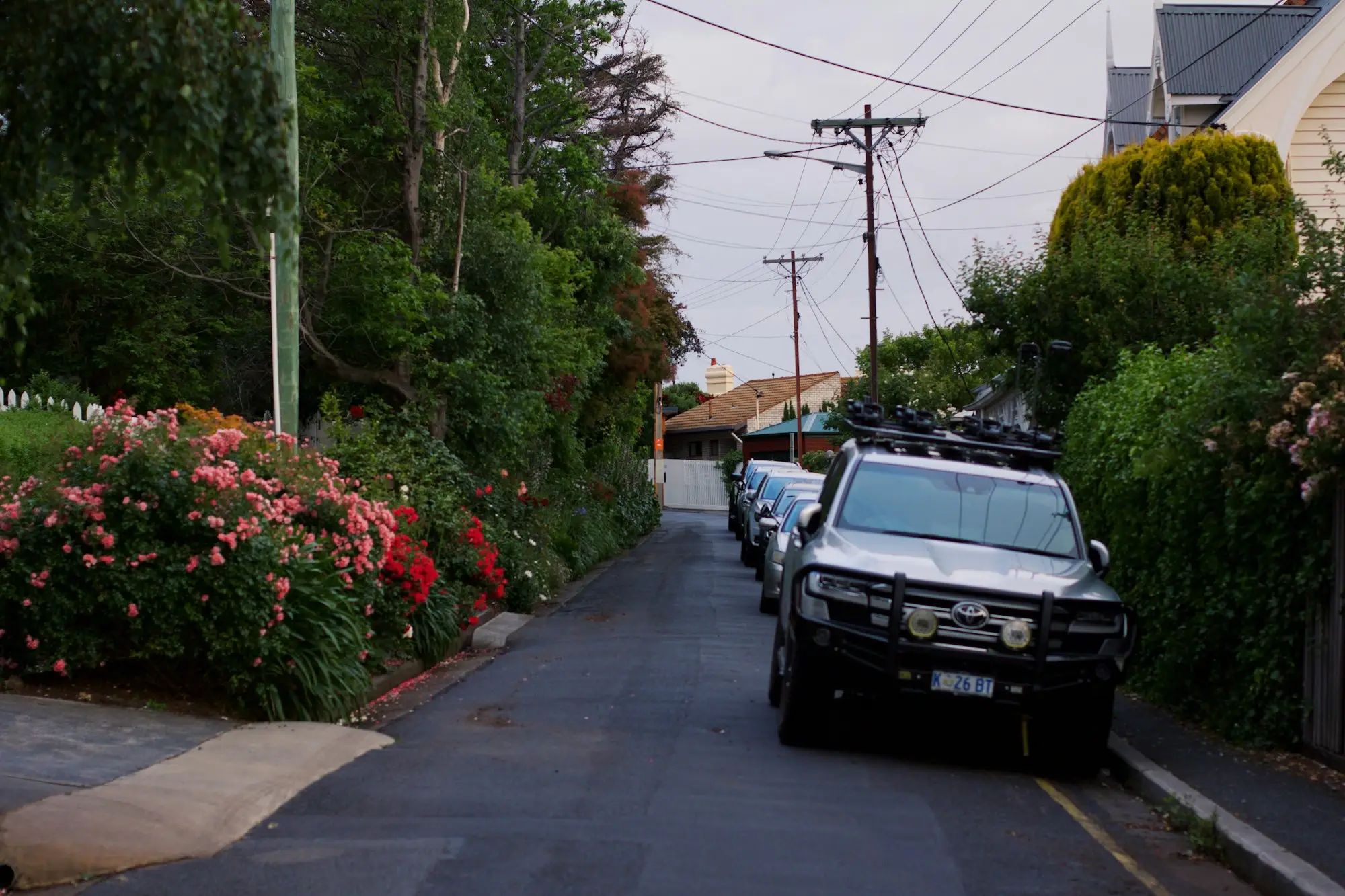 Australian tradie (electrician or plumber) loading a ute or van on a suburban street