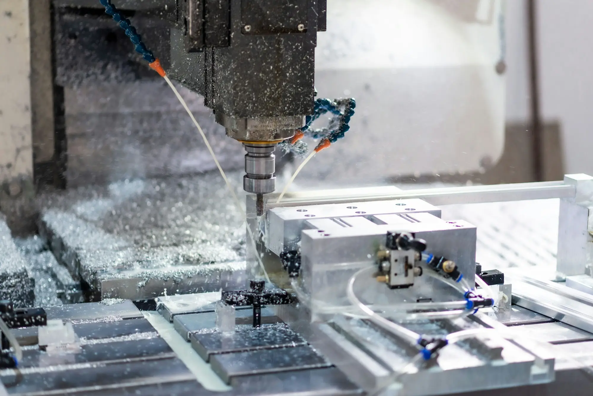 Manufacturing workshop with a CNC machine or lathe and an operator in safety gear
